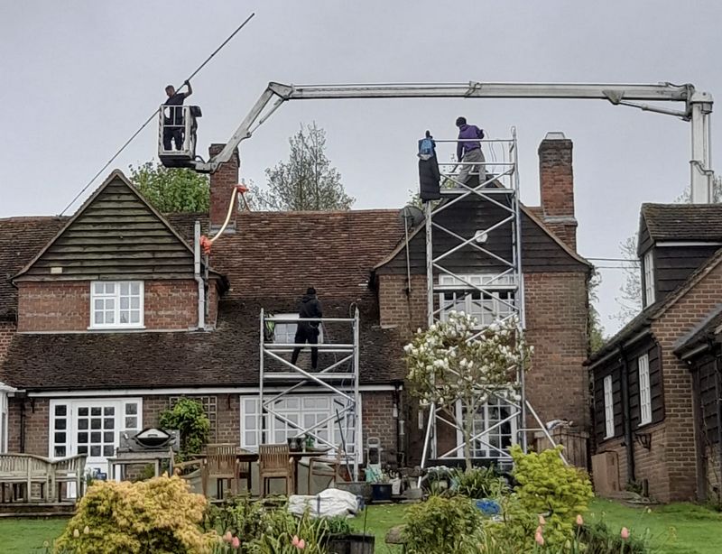 The Roof Moss Cleaners using cherry picker and scaffolding to clean roof safely and professionally in Warlingham, Surrey